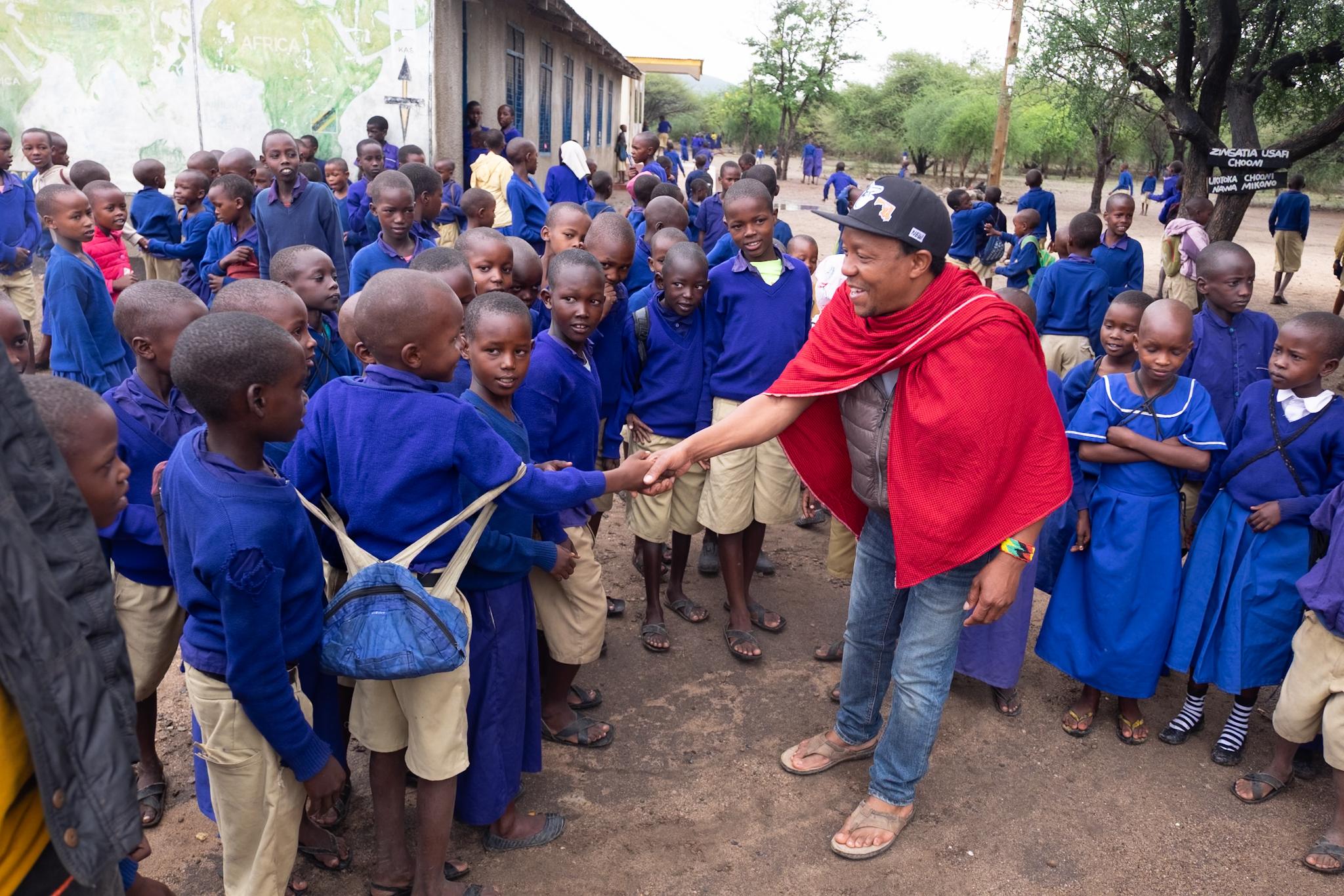 Kinder und Schulgebäude der Esilalei Primary School in Mto Wa Mbu, Tansania, wo AKO neue Toiletten und Klassenräume unterstützt.
