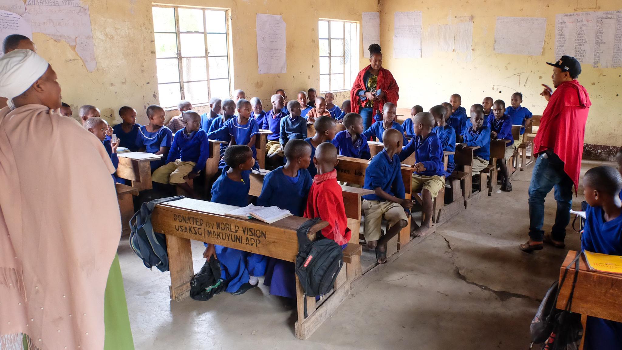 Kinder und Schulgebäude der Esilalei Primary School in Mto Wa Mbu, Tansania, wo AKO neue Toiletten und Klassenräume unterstützt.
